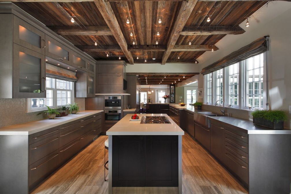 This kitchen mixes a modern look with a rustic ceiling and exposed electrical conduits.