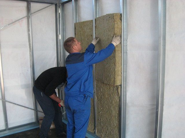 Укладка матов минеральной ваты между направляющими обрешетки