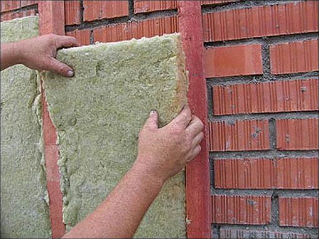 Укладка утеплительных панелей между направляющими обрешетки