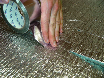 Проклейка стыков пароизоляционной пленки алюминиевым скотчем